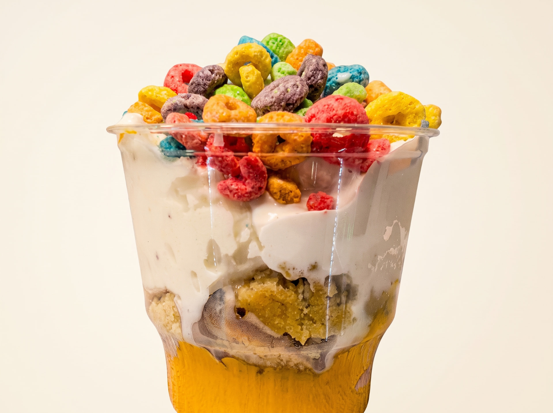 Colorful cereal-topped stuffed cup with creamy gelato and cake layers